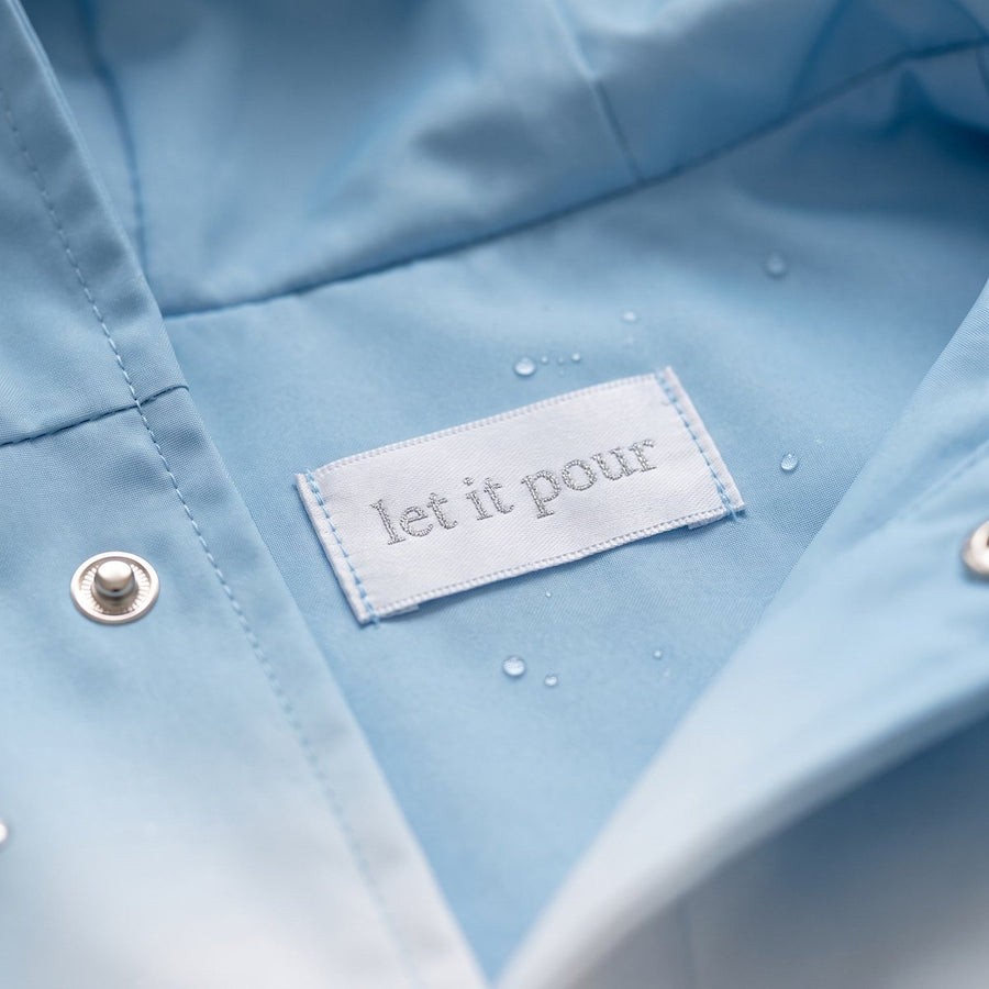 Close-up inside the FROST chest: a small woven label reading let it pour beside a silver snap